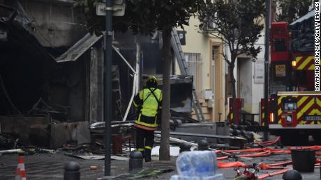 2022年2月14日のサンローラン・ド・ラ・サランクでの爆発の後、消防士が瓦礫と焼けた家の近くに立っています。 