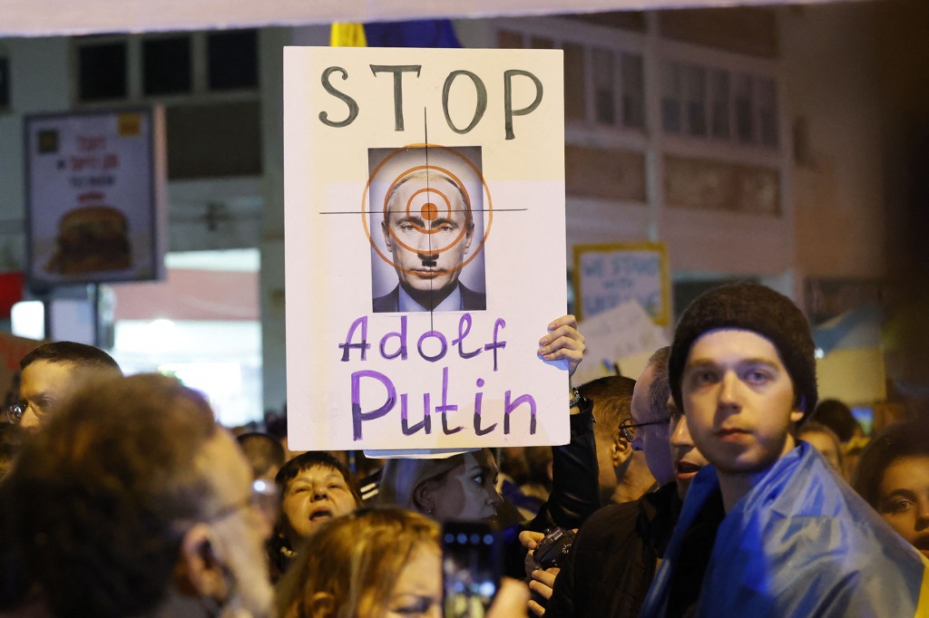 デモ隊は、テルアビブのロシア大使館の前で、侵入に抗議するプラカードを持っています。 