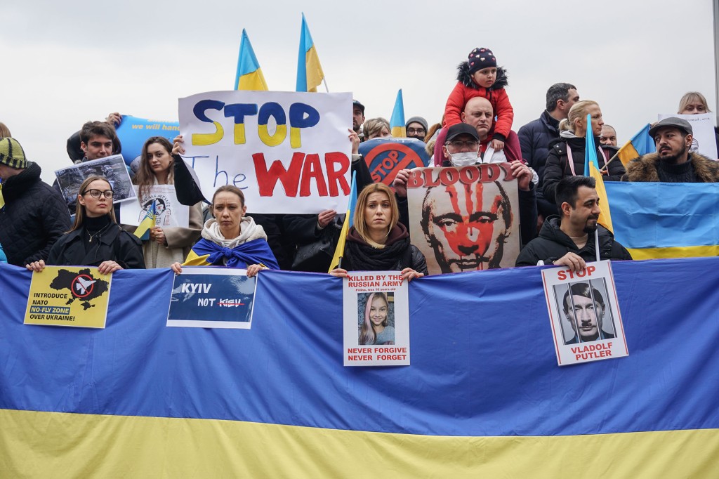 デモ隊は、イスタンブールでのロシアの侵略に反対するデモ中にウクライナの旗と旗を掲げます。