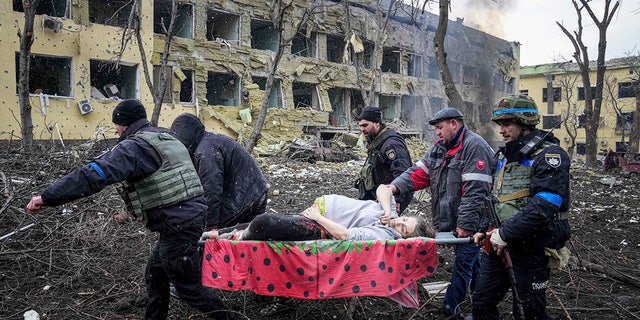 ウクライナの救急隊員とボランティアが、ウクライナのマリウポリにある産科病院の爆撃で影響を受けた負傷した妊婦を輸送します。 