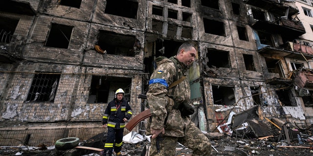 ウクライナの兵士と消防士は、2022年3月14日月曜日、ウクライナのキエフで爆弾攻撃を受けた後、破壊された建物を検査します。 
