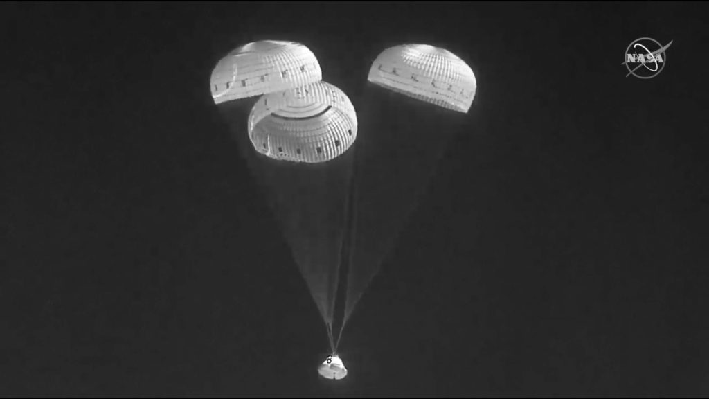 赤外線画像は、ニューメキシコ州のホワイトサンズミサイルレンジに着陸するために降下するパラシュートを使用したボーイングスターライナーカプセルを示しています。