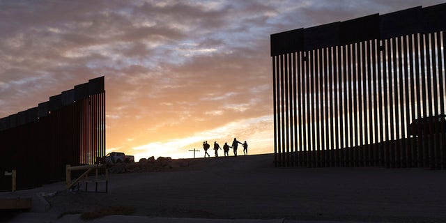 ファイル-ブラジルからの移民家族は、亡命を求めてメキシコからアリゾナ州ユマに渡った後、国境壁の隙間を通過して米国に到着します。