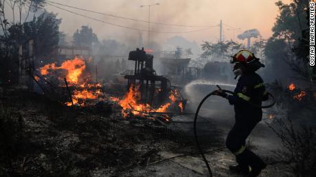 消防士は7月20日にギリシャのアテネ近くのパリニで火を消そうとします。