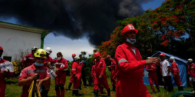キューバ赤十字社のメンバーは、2022 年 8 月 6 日土曜日、キューバのマタザナスで、前夜の雷雨の間に発生した火災を消火するために消防士が働いているため、マタンザス スーパータンカー基地に移動する準備をしています。