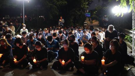 8月8日に自宅が浸水した後、家族の死を追悼するために、8月11日にソウルでろうそくの明かりで追悼式を行う小さな群衆.