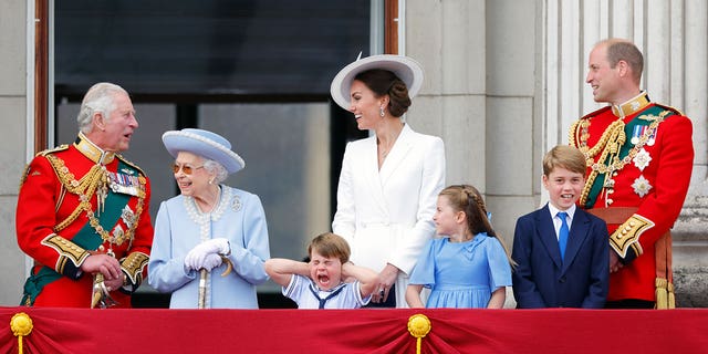 (LR) 6 月、エリザベス 2 世女王、ルイ王子、ケイト ミドルトン、シャーロット王女、ジョージ王子、ウィリアム王子と一緒にバッキンガム宮殿のバルコニーでポーズをとる当時のチャールズ皇太子。 