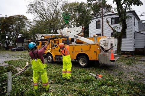 労働者は、土曜日にハリファックスの倒れた木に機械が到達できるように、倒れたワイヤーを持ち上げます。