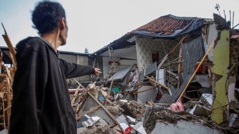 2022 年 11 月 21 日、インドネシアの西ジャワ州チアンジュールを襲った地震で被害を受けた住宅の近くに立つ男性。
